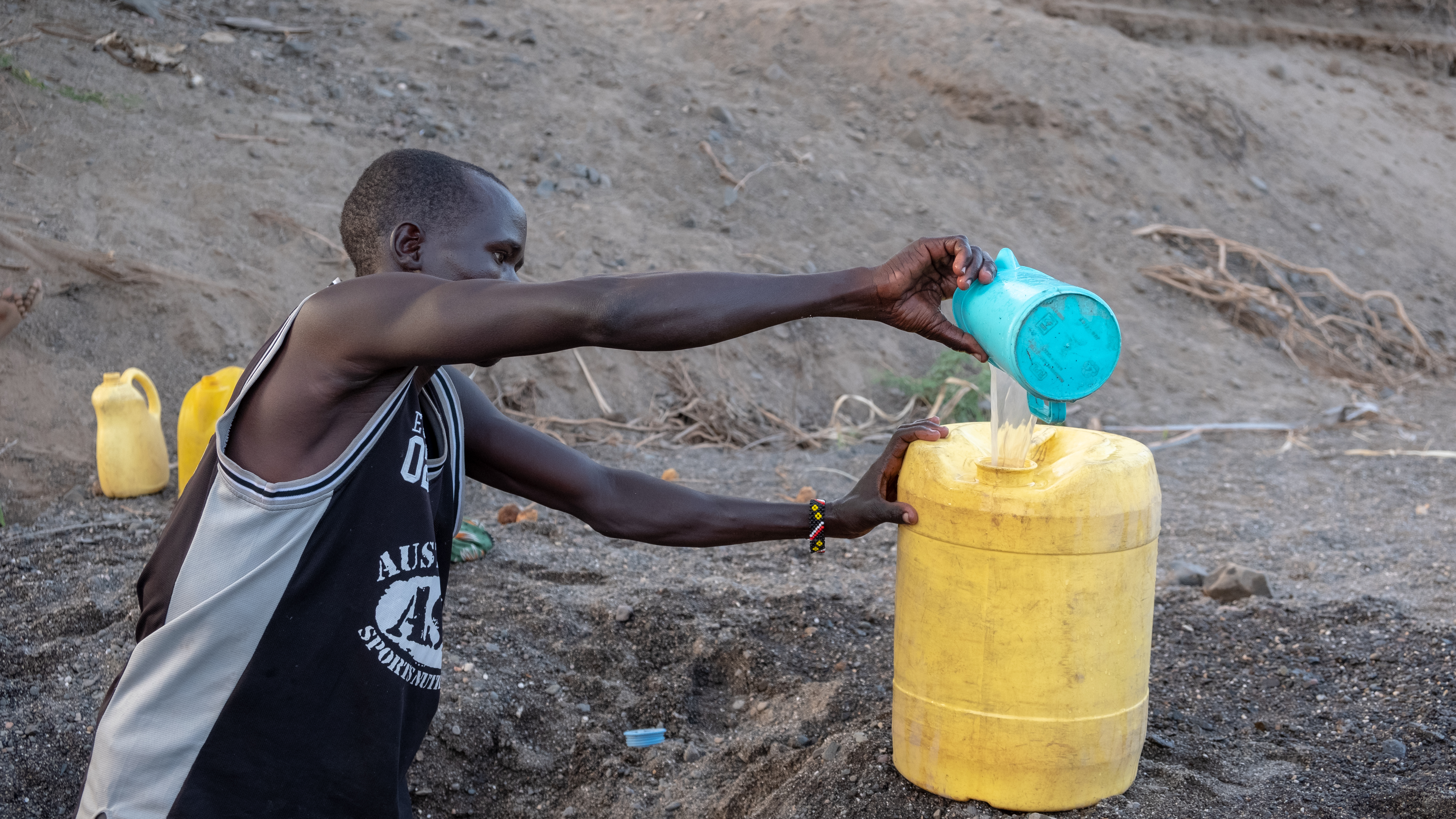DSCF8263 Man fetching water for his family from a shallow well in a dry river bed