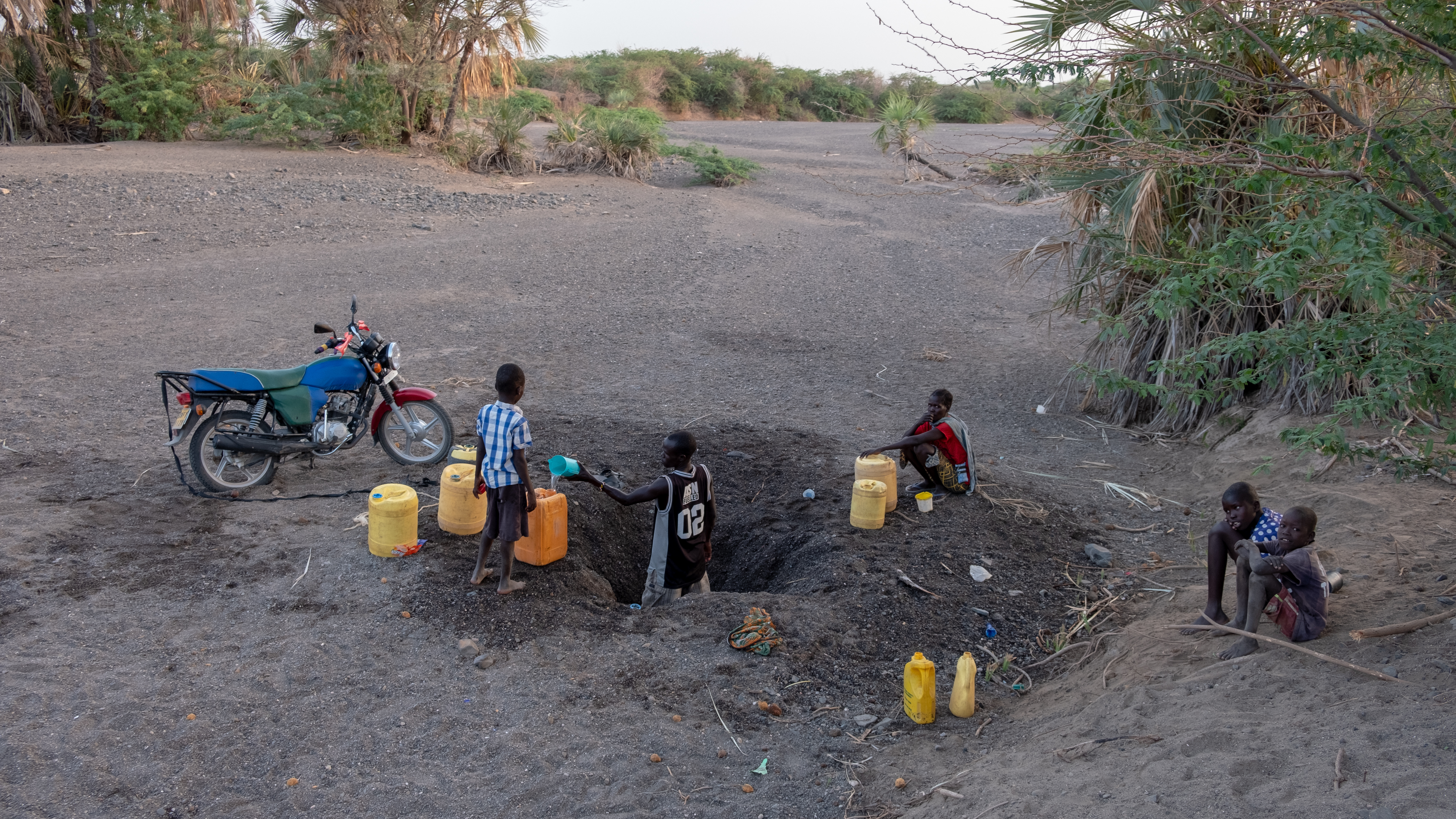 DSCF8284 Man fetching water for his family from a shallow well in a dry river bed wide