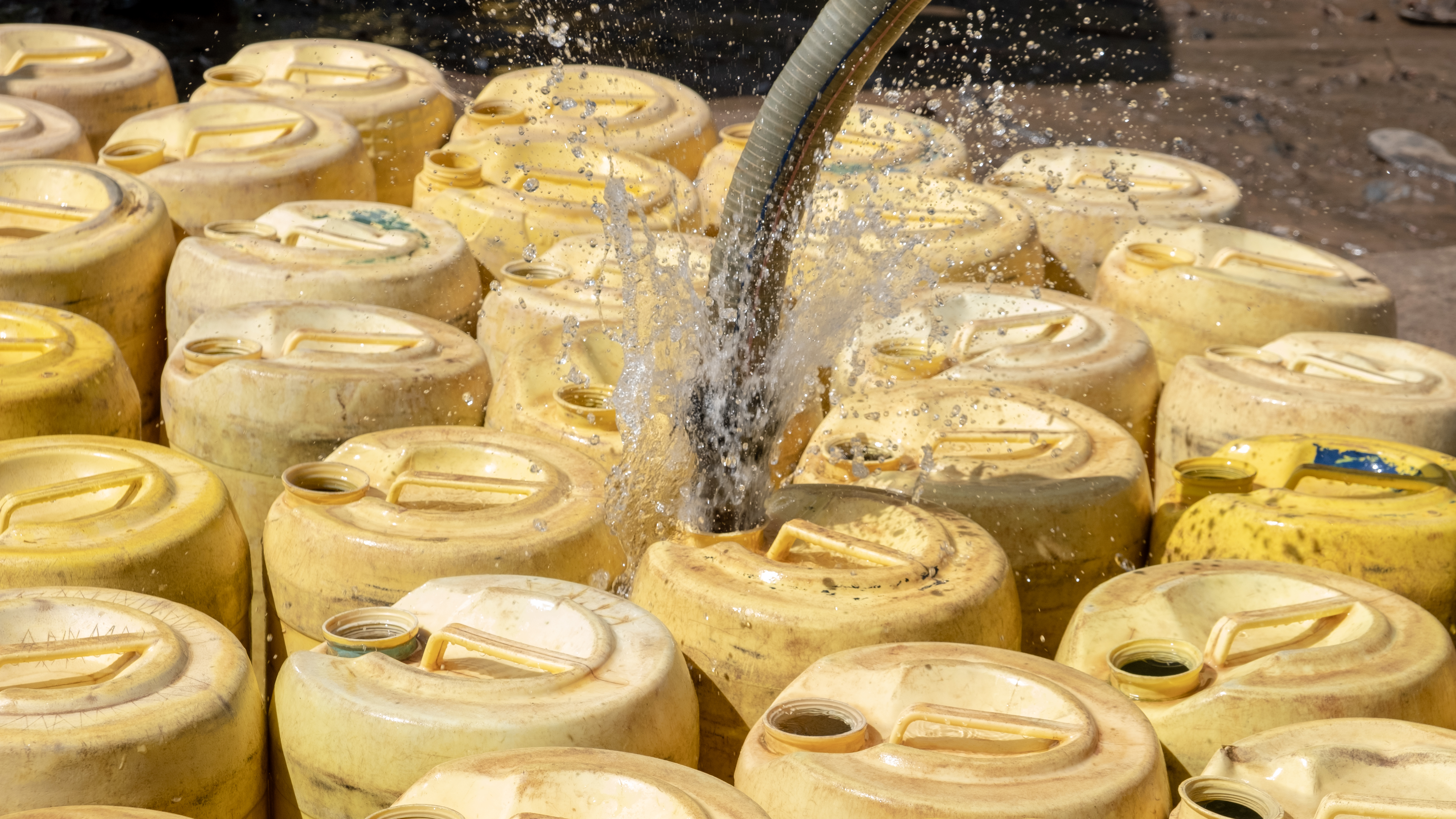 DSCF8520 filling up jerricans with water from the shallow well