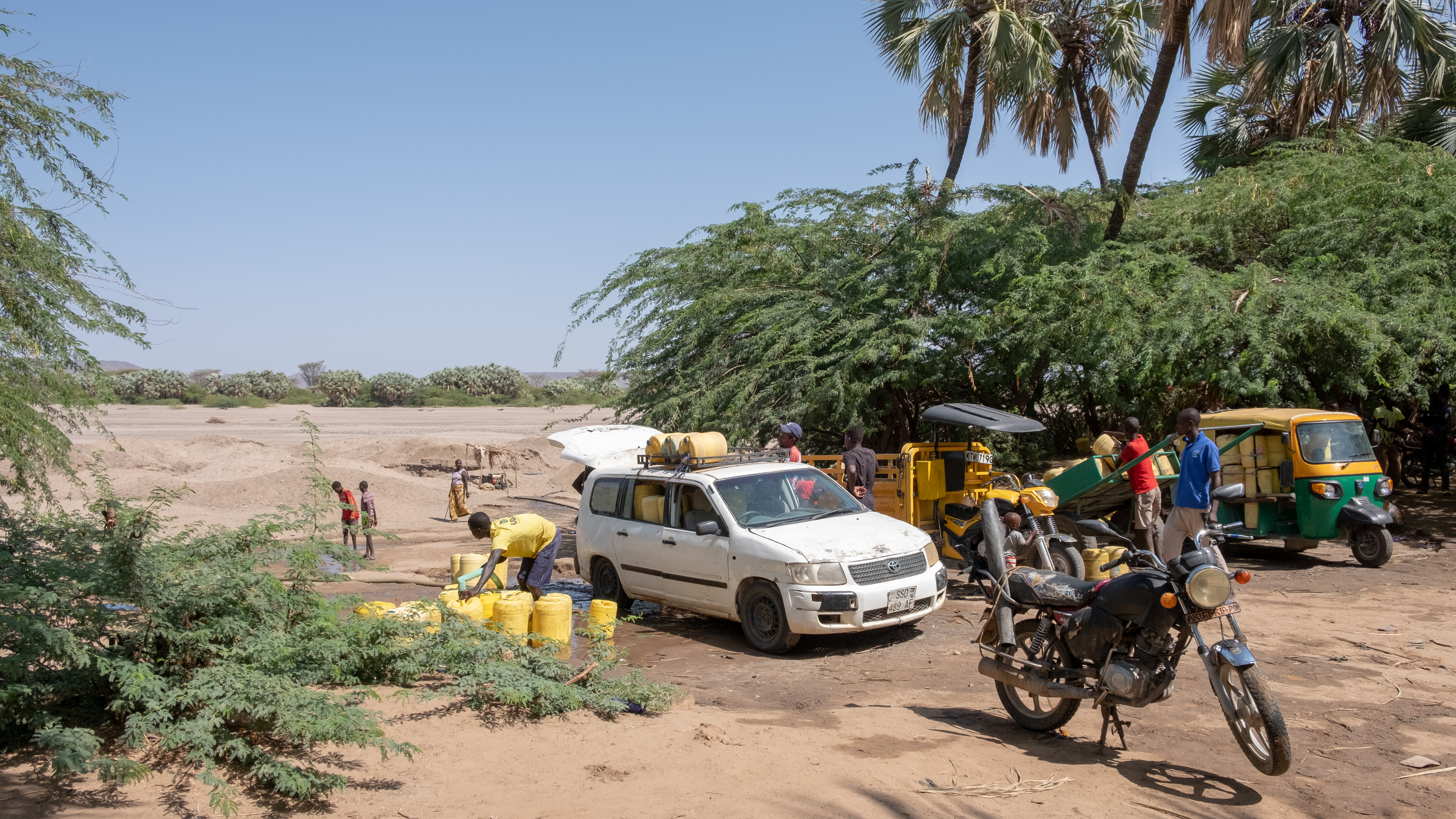 DSCF8540 Water vendors filling up their jerricans with water from the shallow well as other vendors wait for their turn.